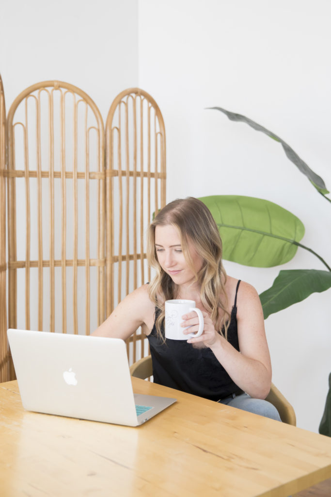 Female drinking coffee while working on computer