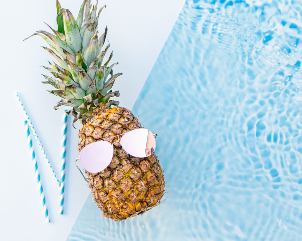 Pineapple wearing sunglasses on blue and white background