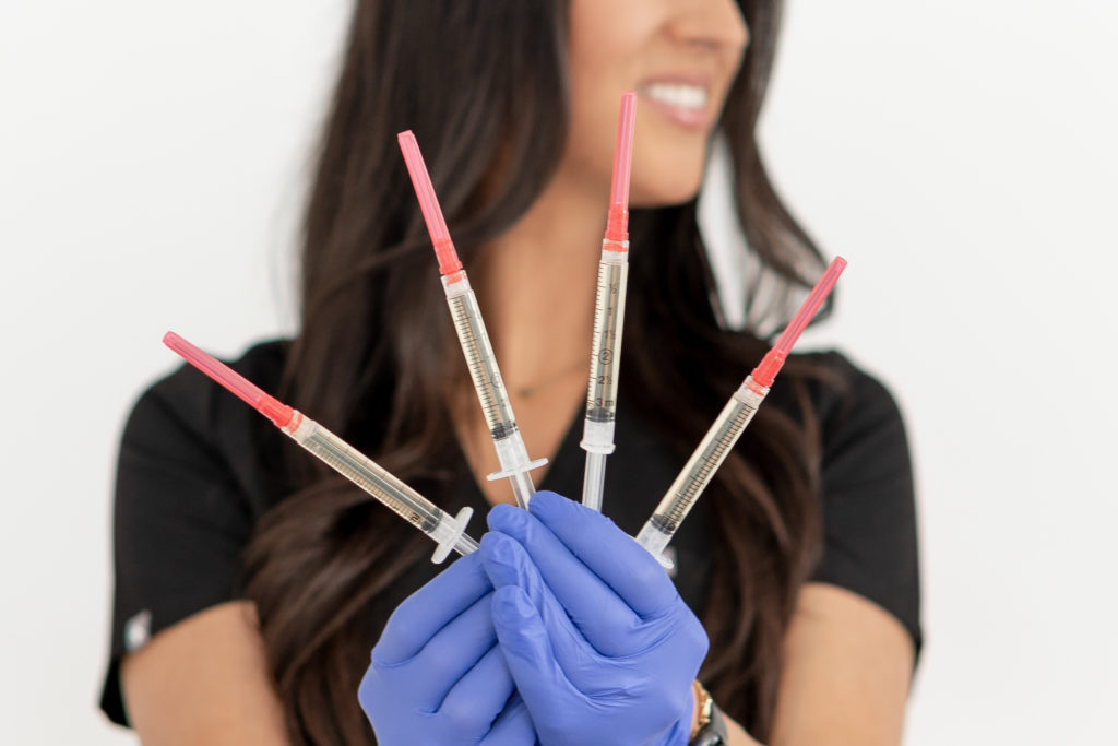 Nurse holding injector needles with gloves